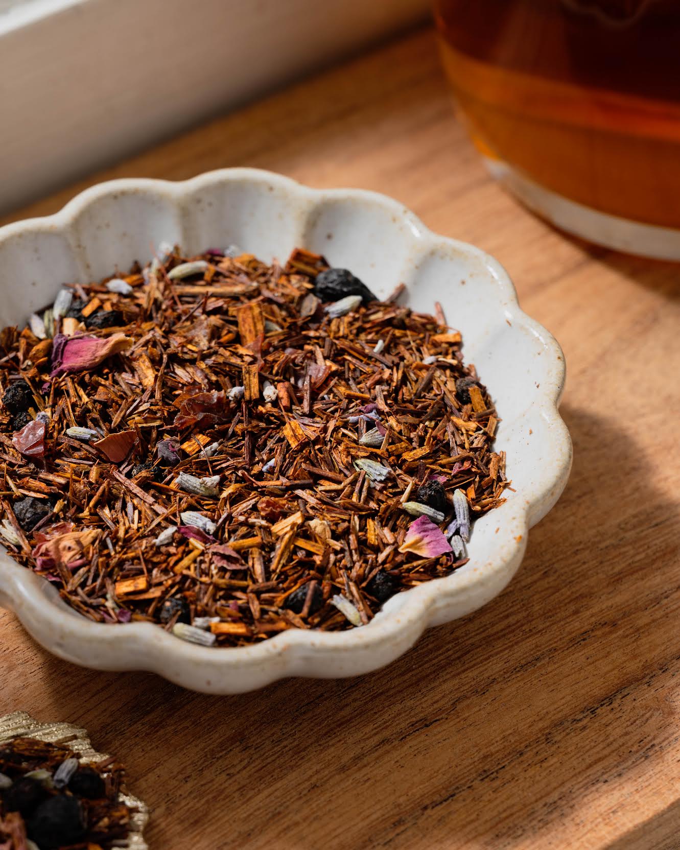 Elderberry Meadow Rooibos Herbal Tea shown as loose leaf tea in a small white bowl.