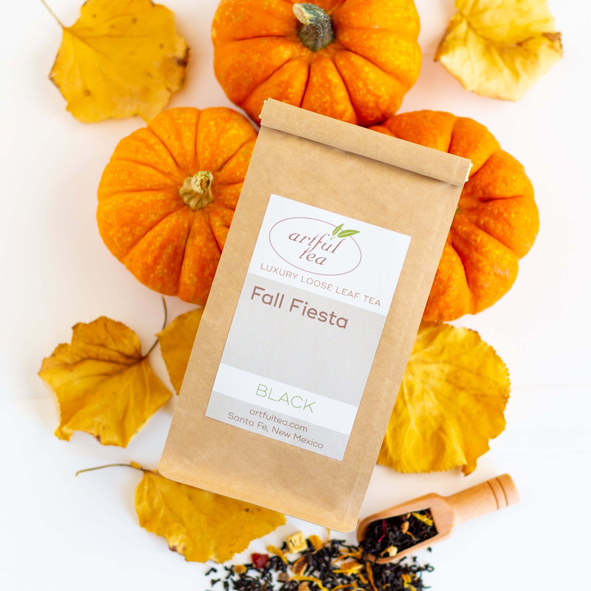 Fall Fiesta Black Tea shown from above with loose tea leaves, fall leaves, and pumpkins in the background.