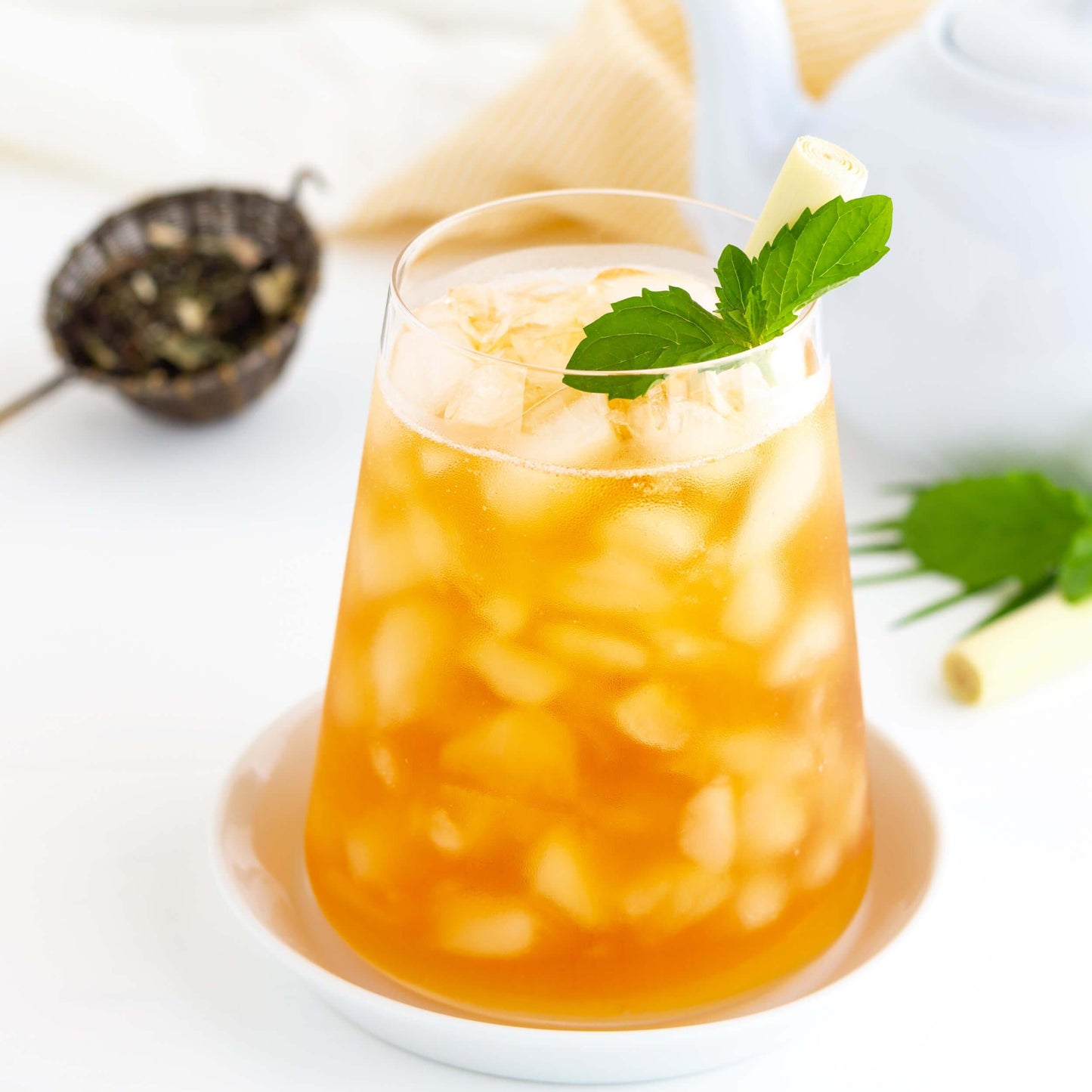 Lemon Mint Ménage Organic Black Tea shown as iced tea with sprig of mint and lemongrass