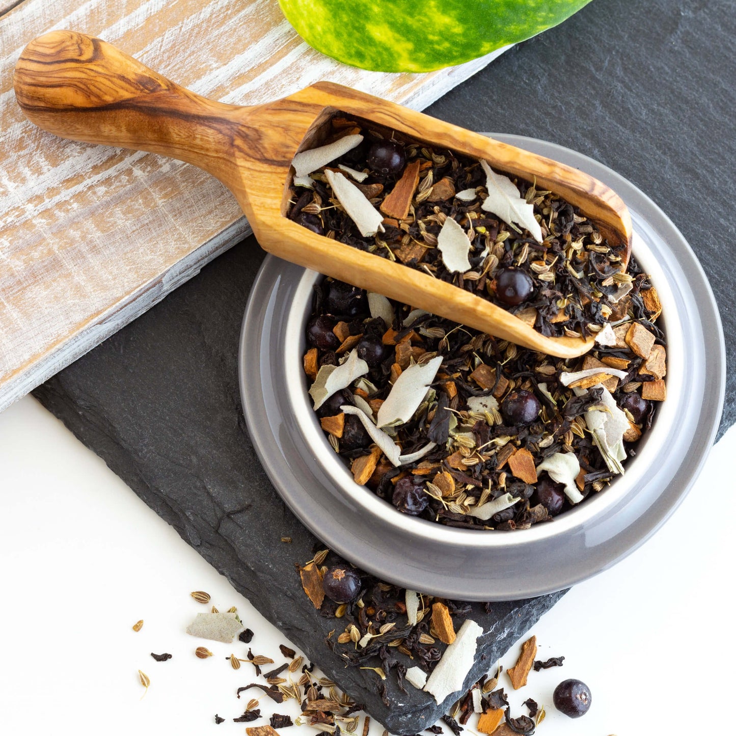 Santa Fe Sage Black Tea shown in a wooden scoop and a gray dish.