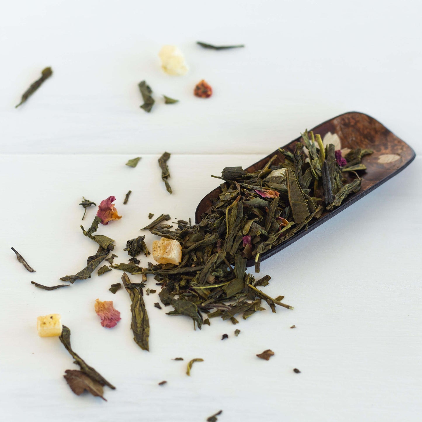 Spring Fancy Green and White Tea shown as loose leaf tea spilling out of a wooden scoop.