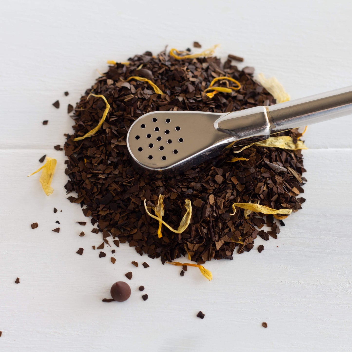 Nutty Mocha Mate Tea shown as loose leaf tea in a circle with a bombilla on top of it.