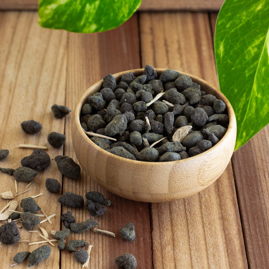 Ginseng Oolong Tea shown as loose leaf tea in a wooden bowl with loose tea around.