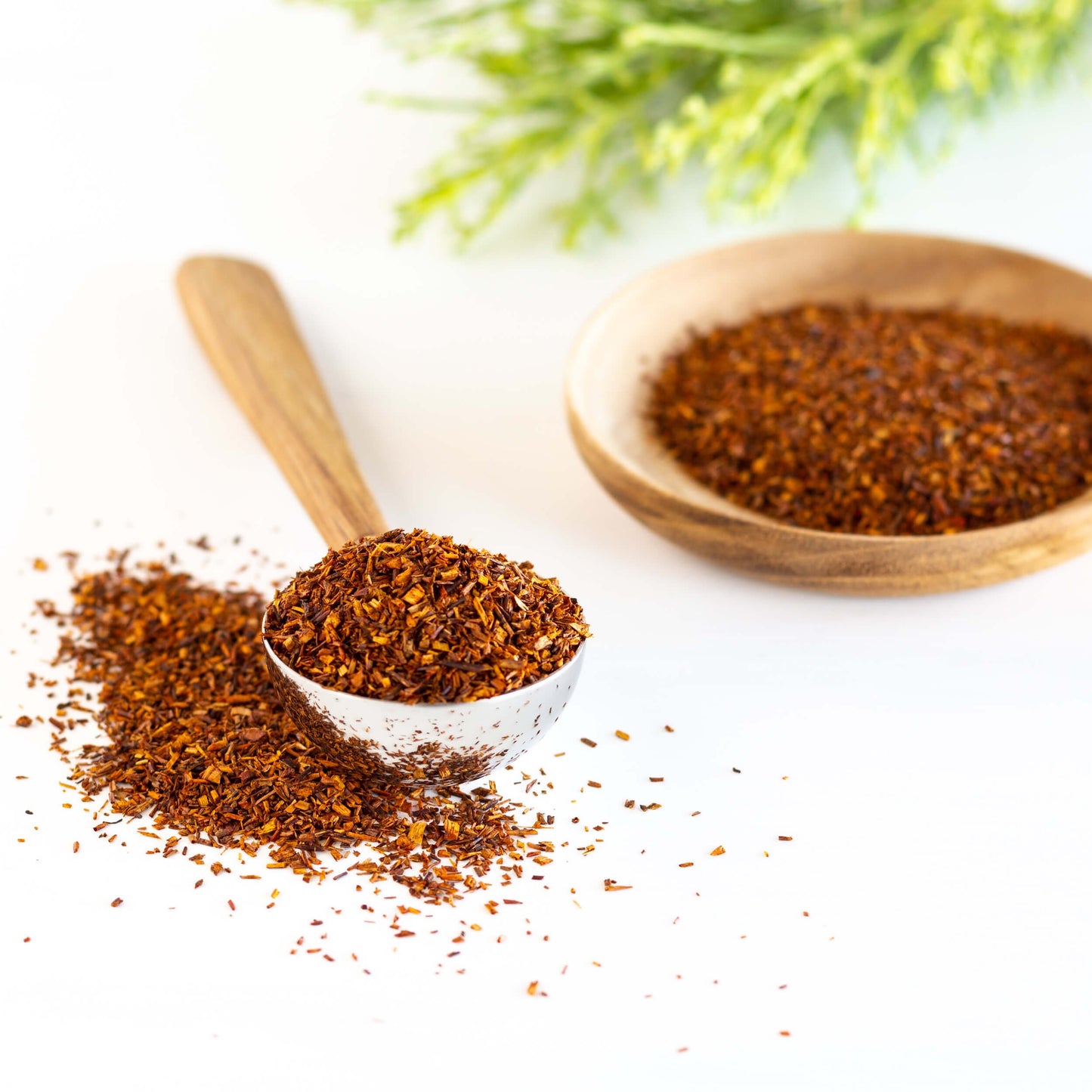 Earl Grey Rooibos Herbal Tea shown as loose leaf tea inside of a scoop and wooden bowl.