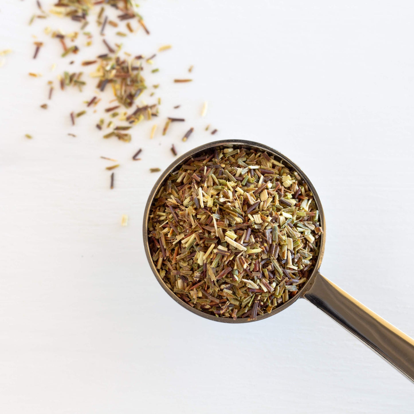 Green Rooibos Herbal Tea shown from above as loose leaf tea in a teaspoon.