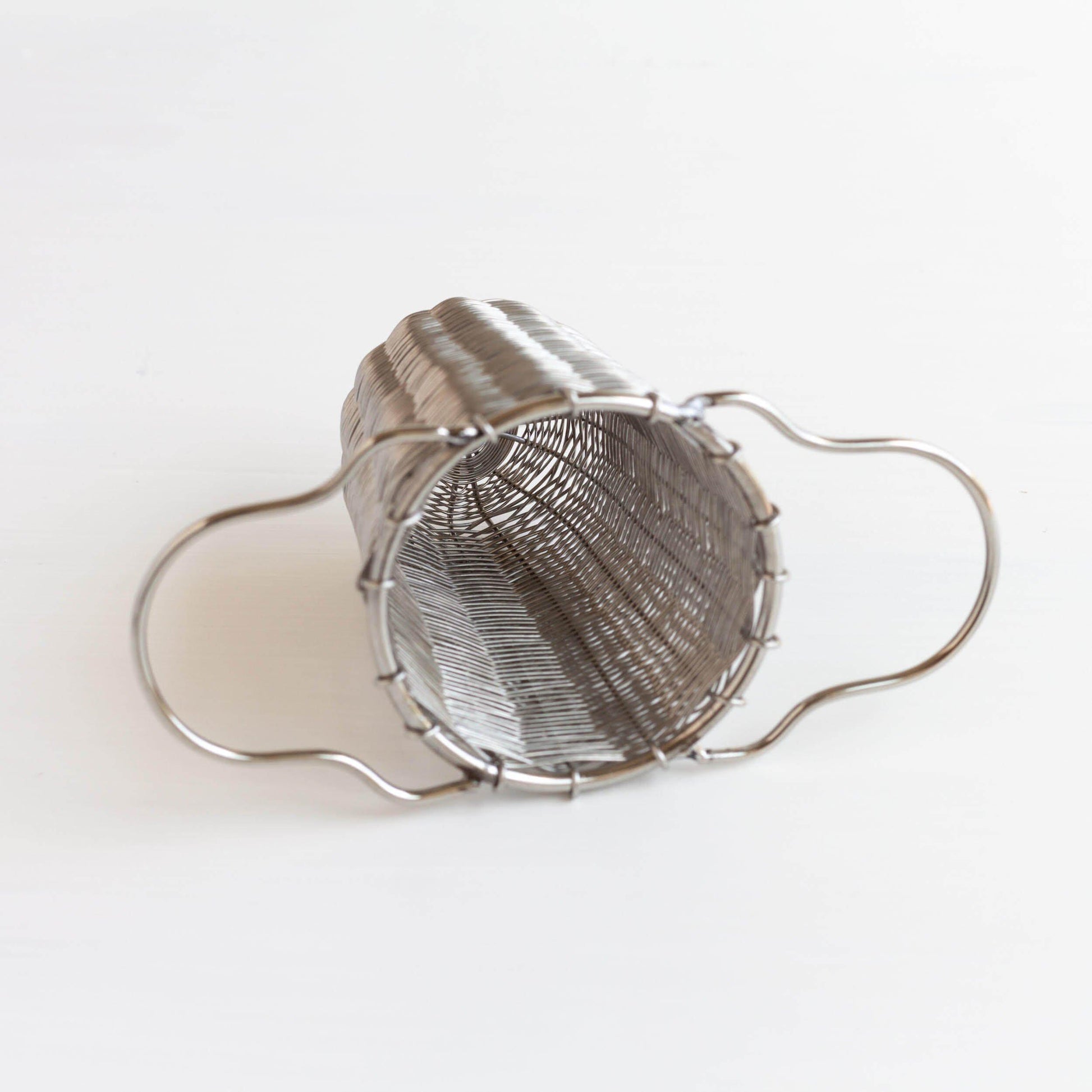 Metal tea strainer on its side