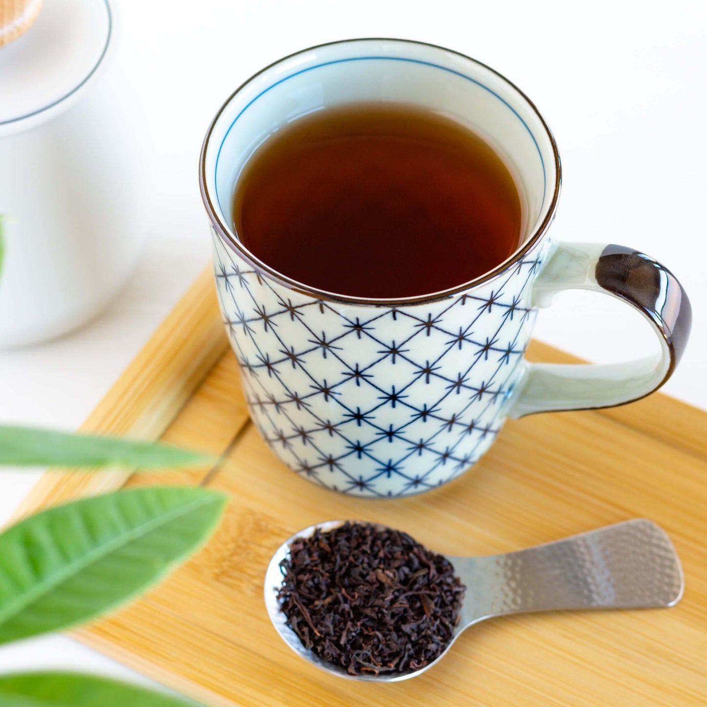Organic Ceylon Black Tea shown brewed in a mug and with loose leaves in a scoop
