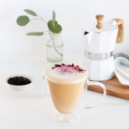 Earl Grey Organic Black Tea shown as a London Fog in a glass mug with rose petals on top