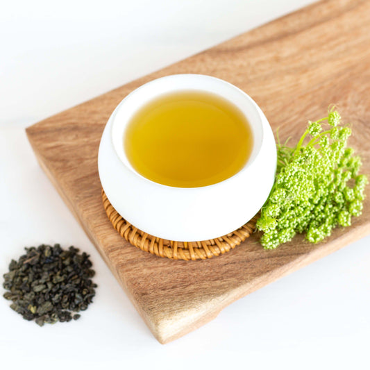 White cup of Gunpowder Organic Green Tea on wood tray
