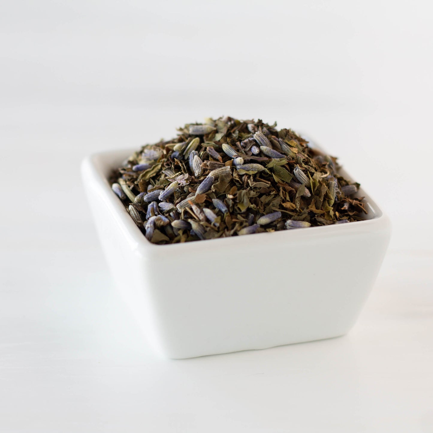 Lavender Mint Organic Herbal Tea shown in close up as loose tea leaves in a small square white dish