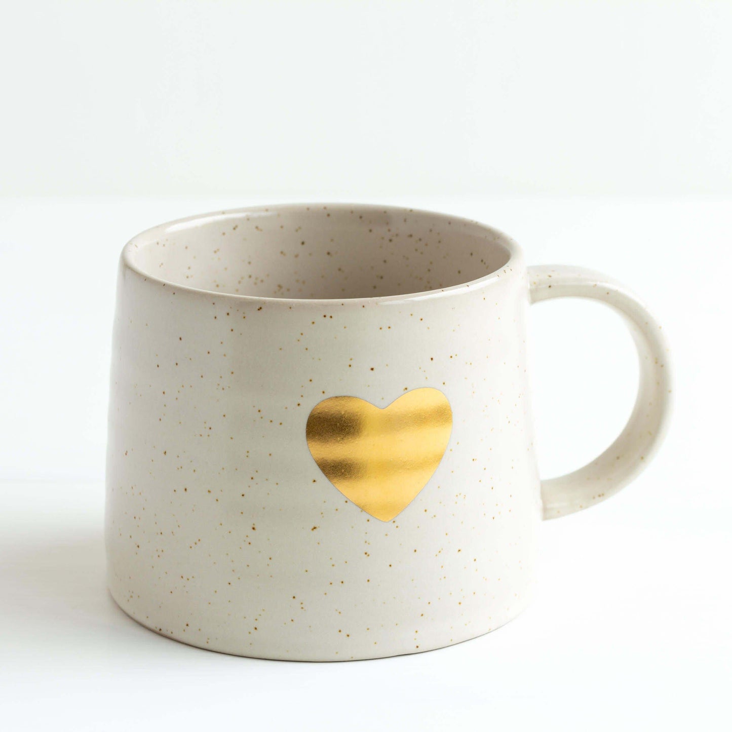 White mug with gold heart catching the light