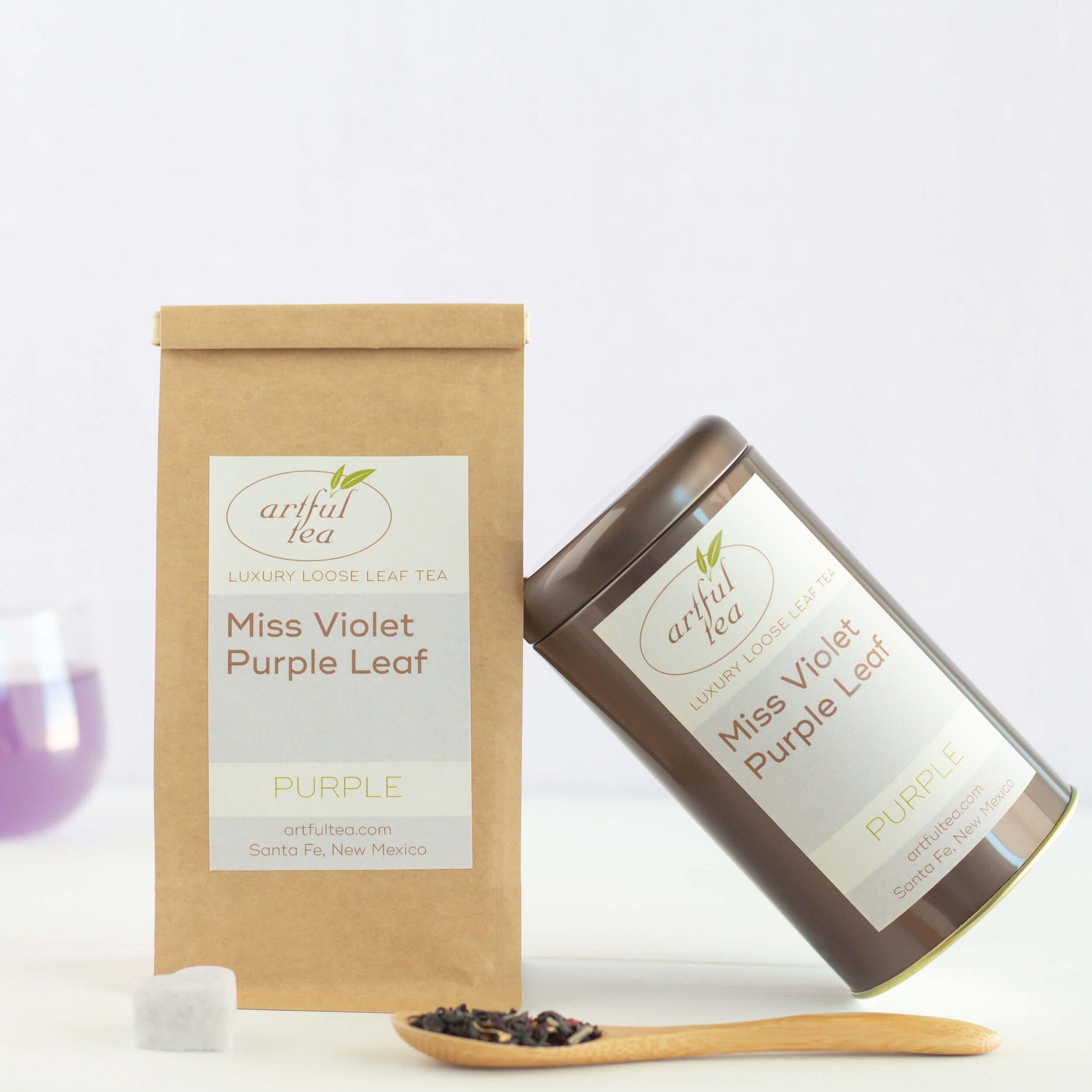 Bag and tin of Miss Violet Purple Leaf Tea with spoon