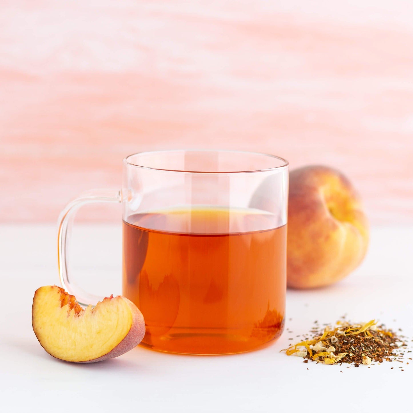 Glass mug of Peach Rooibos Organic Herbal Tea with peaches