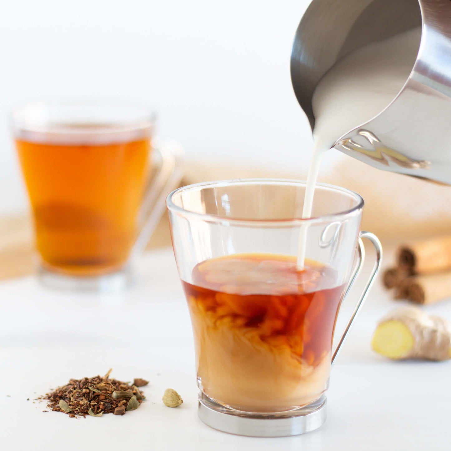 Glass mug of Rooibos Chai Organic Herbal Tea with cream added