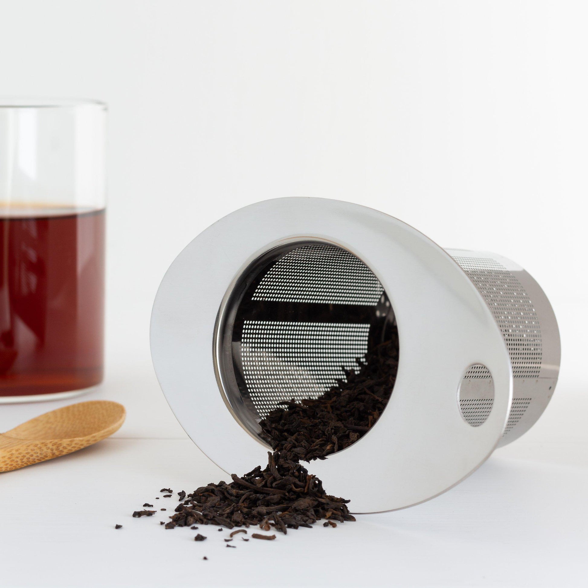 Stainless Steel Tea Infuser Basket (lying on its side with tea leaves spilling out)