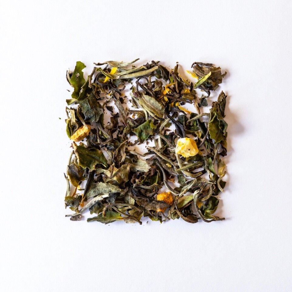 Mango Pear Organic White Tea shown from above as loose tea leaves displayed as a square shape on a plain white background